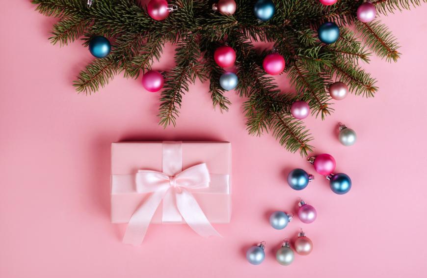 Rosa Weihnachtsmotiv mit Geschenk und Kugeln, Hintergrund des OK-Adventskalenders 2025